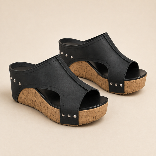 Paire de sandales compensées noires sur fond beige